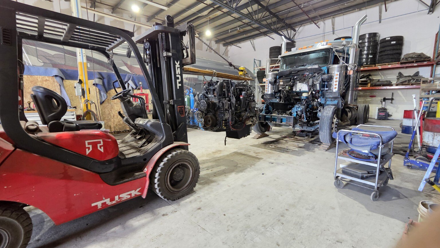 Camion lourd en réparation avec moteur démonté dans un atelier